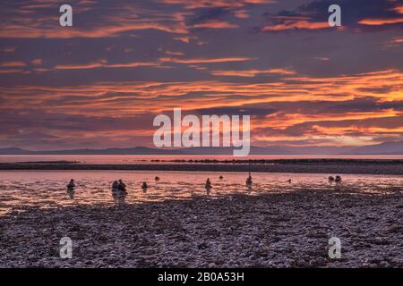 Sunset on the Argyle Hills opposite Largs on the West Coast of Scotland and some unusual stone formations in the foreground of the image. Stock Photo