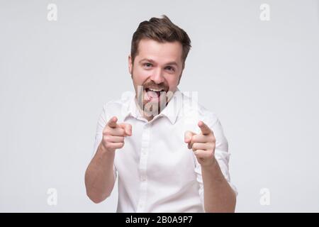 Handsome bearded mature man pointing at camera pointing at you. You are excellent guy. Studio shot Stock Photo