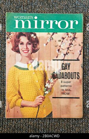 Women's Mirror knitting pattern showing lady wearing yellow cardigan, c.1960's displayed on knitted background. Editorial only Stock Photo
