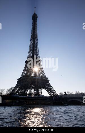 The sun rises behind the Eiffel Tower in Paris, France. Stock Photo