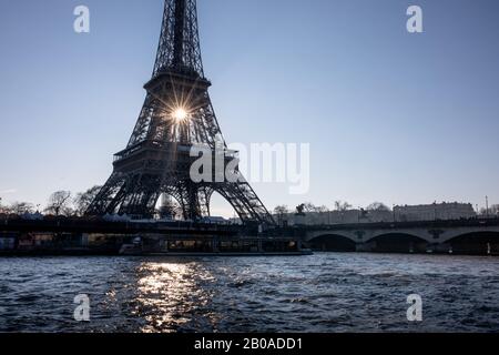 The sun rises behind the Eiffel Tower in Paris, France. Stock Photo