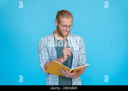 Young thoughtful dreamy man hold pen think plan make notes diary Stock Photo