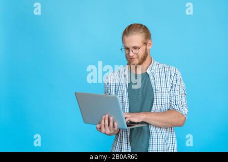 Bearded young businessman student hold modern laptop type e-mail copy space Stock Photo