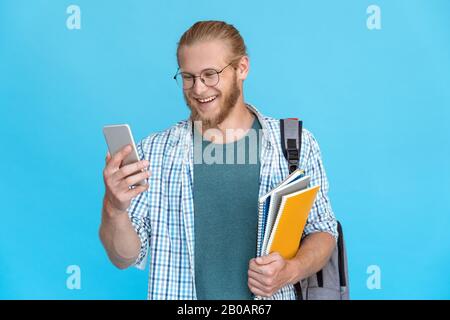 Bearded young man glasses hold modern smart phone smile at screen skype call Stock Photo