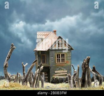 Deserted Two-Story House and Dead Trees on Lawn Stock Photo
