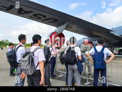 Singapore - Feb 12, 2020. Visitors looking at military aircrafts in Changi, Singapore. Defense costs are increasing, especially in East Asia. Stock Photo