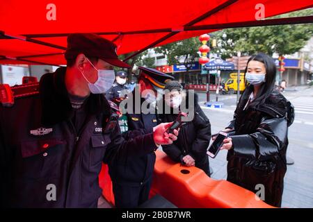 Chinese urban management officers verify the registrations of tourists for their visit to the Confucius Temple scenic spot after it reoponed to the pu Stock Photo