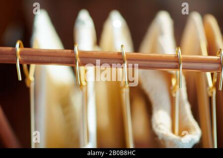 Upper view of modern copper clothes rack with clothes on hangers. Stock Photo