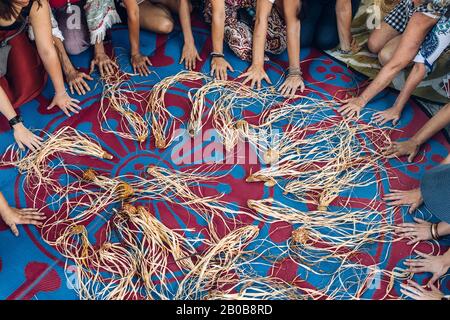 Different ages and nationalities females hands around their weaving craft on the carpet after the workshop. Diversity and inclusion in creativity. Women multicultural community in Australia. Stock Photo