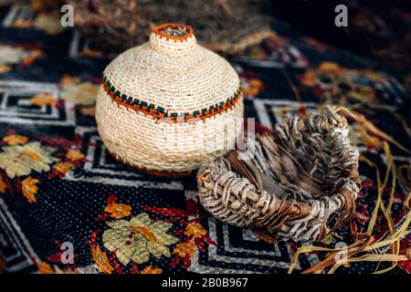 Different hand made weave basckets on table. Craft workshop. Close up shot. Stock Photo