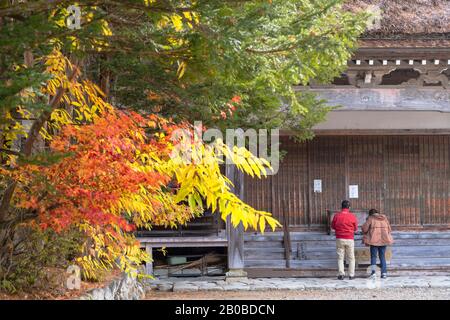 Couple at temple, Ogimachi (UNESCO World Heritage Site), Shirakawa-go, Toyama Prefecture, Japan Stock Photo