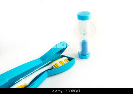 Toothbrush in a plastic case and dental Hourglass on white background Stock Photo