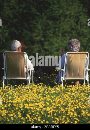 An elderly couple sat on deck chairs on a beach Stock Photo - Alamy