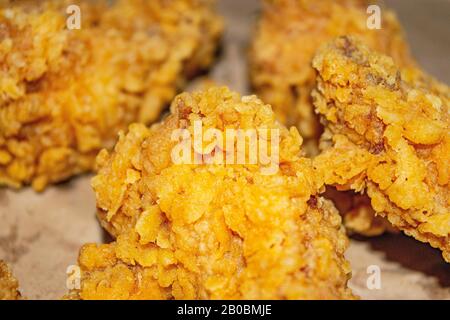 Chicken wings fried in breadcrumbs on a grey paper background. Close up Stock Photo