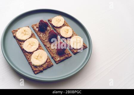 Peanut butter toast with banana and raspberry Stock Photo
