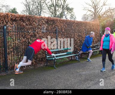 Runners stretching at Shrewsbury Parkrun in the Quarry, Shropshire, England, UK. Stock Photo