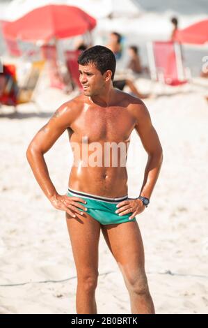 RIO DE JANEIRO - FEBRUARY 11, 2011: A young Brazilian man takes a break from a volleyball game on Copacabana Beach. Stock Photo