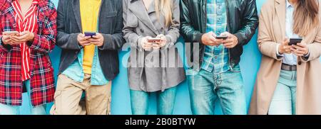 Group of friends using smart mobile phones app - Teenagers addiction to new technology trends - Concept of youth, tech, social and friendship - Focus Stock Photo