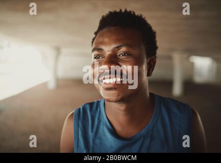 Happy portrait of a happy young african american young athlete looking away at outdoors Stock Photo