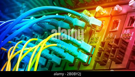 Fiber Optic cables connected to optic ports and UTP, Network cables connected to ethernet ports. Stock Photo