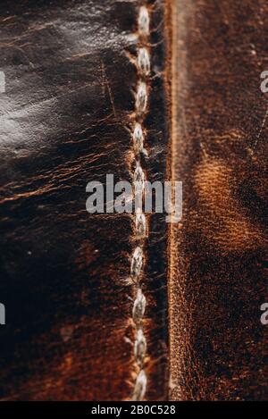 vintage shabby leather of dark brown color, handmade sewing method. Leather craft. Close-up Stock Photo