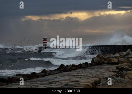 Dramatic stormy winter sunset at the Douro river mouth north pier and beacon. Stock Photo