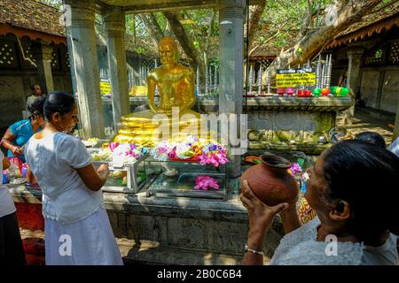 Kalutara, Sri Lanka - January 2020: Women making offerings at the Asokaramaya Buddhist temple on January 30, 2020 in Kalutara, Sri Lanka. Stock Photo