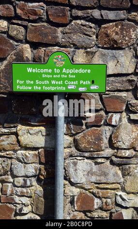 Green Welcome to Appledore Metal Signpost next to a Stone Wall by the Entrance to the Village on the South West Coast Path, North Devon. England, UK. Stock Photo