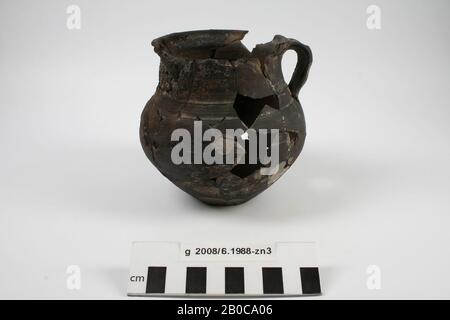 Cooking pot made of black, rough-walled earthenware with ear and lid, Stuart 213a. On the inside there are still caked cooking remains. Glueing, part of the edge missing, gaps in the wall and bottom, surface damage, pot, pottery, h: 11.6 cm, diam: 11.3 cm, br: 12.2 cm, roman 15-30 AD. , Netherlands, North Holland, Velsen, Velsen, Velsen I Stock Photo