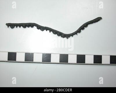 Fragment leather belt with fittings (copper alloy). On the belt are 13 lead studs with round and round caps and 7 decorative nails without cap. The color of the batter is dark gray to black because of the corrosion of the lead. There is no space between the caps and the fittings are as wide as the leather. In five places both the nail and the cap are missing, which can be seen from the print in the leather. Thickness of the belt with batter is 0.6 cm. The diameter of the batter is 0.45 cm (due to corrosion a few caps are wider) and the thickness is 0.35 cm. The diameter of the nails is 0.1 cm Stock Photo