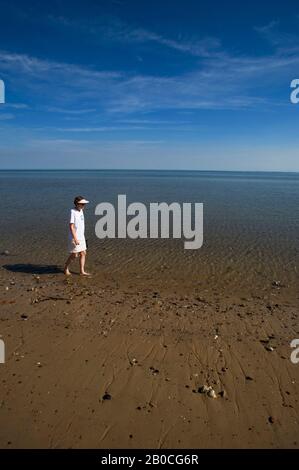 GERMANY, SCHLESWIG HOLSTEIN, NORTH SEA, NORTH FRISIAN ISLANDS, SYLT ISLAND, LIST, WOMAN WALKING ON BEACH AT LOW TIDE, MODEL RELEASED Stock Photo