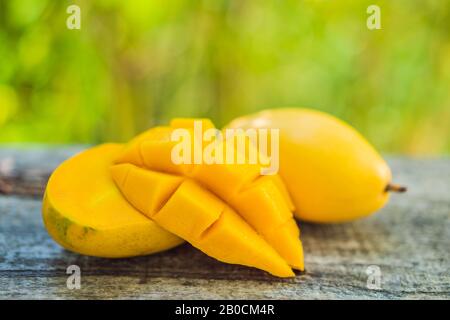 Mango fruit and mango cubes on the wooden table Stock Photo