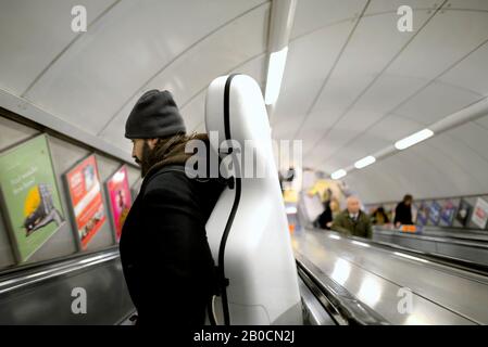 London, England, UK. Man carrying a cello down an escalator in a tube station Stock Photo