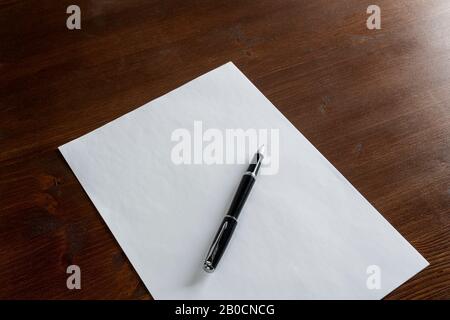 a pen resting on a white sheet of paper Stock Photo