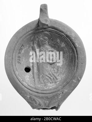 A red-nested lamp with a round body on a flat base. The concave mirror is surrounded by recessed concentric circles and is decorated with a relief of Athena 'and profile'. The short, broad spout was decorated with volutes. The small filling hole is to the left of the figure., Oil lamp, earthenware, terracotta, 3.4 x 9 x 6.8 cm, 1st and 2nd century AD. 1-200, Turkey Stock Photo