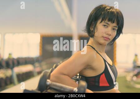 Young beautiful Asian woman working out at the gym Stock Photo