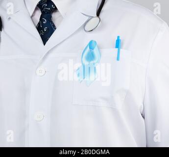 on the pocket pinned a blue ribbon in the shape of a loop, symbol of the fight and treatment of prostate cancer Stock Photo
