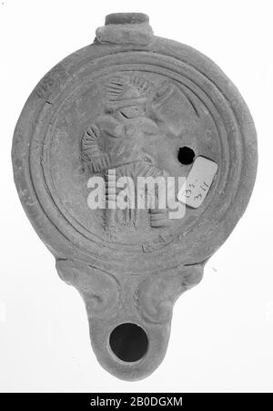 A red-nested lamp with a round body on a flat base. The concave mirror is surrounded by recessed concentric circles and is decorated with a relief of an armed gladiator or warrior. The short, broad spout with a large fire hole is decorated with volutes and round closed. The small filling hole is to the right of the figure., Oil lamp, earthenware, terracotta, 3.5 x 11.9 x 8 cm, 1st and 2nd century AD. 1-200, Asia Stock Photo