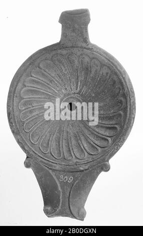 A gray-gray lamp with a round body on a flat base. The concave mirror is surrounded by recessed concentric circles and is decorated with a rosette with the small filling hole in the center. The short, broad spout with a small fire hole is decorated with volutes. The ear was turned on vertically., Oil lamp, pottery, terracotta, 4.7 x 12.8 x 8.4 cm, 1st and 2nd century AD. 1-200, Italy Stock Photo