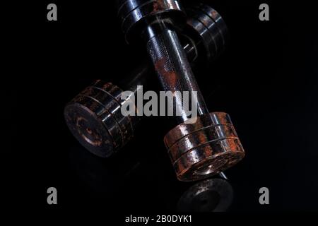 Two old rusty dumbbells on black background Stock Photo
