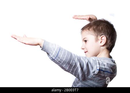 Little boy moving in dance close-up on white background. Happy boy dreams to fly. Stock Photo