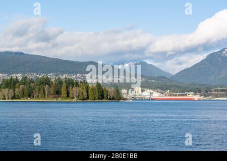 Vancouver, British Columbia, Canada - December, 2019 - Mountain View with clouds in a Beautiful blue sky day at West Coast seaport. Stock Photo