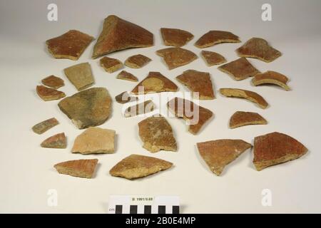Loose shards belonging to an earthenware jug. The fragments show a flat bottom, a sloping wall, a flat handle and a narrow and concave neck with a rounded edge. Manufactured on the wheel. The clay is light brown in color, has a medium and hard texture and is mixed with small orange stones or earthenware, quartzite, fine sand and lime. On the outside a vertical and diagonally polished red coating with rotating spurs, black and white-gray touch. Part of the surface has been brown-red approved. The bottom has an orange surface. On the inside of the rim and neck a red coating. Elsewhere a light Stock Photo