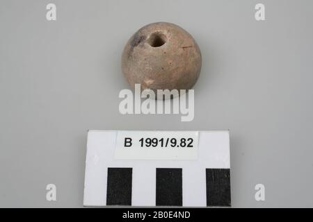 Spindle of limestone. The underside is flat. The top is about half-round in shape. Drilled in the middle around the length (diameter through hole: 0.7 cm). The surface is light brown in color and contains thin concentric grooves, dark brown and gray discolouration (presumably fire traces) and small reddish brown spots., Tools, stone, limestone, H 2.4 cm, D 3.7 cm, Iron Age II 925-539 BC, Jordan Stock Photo