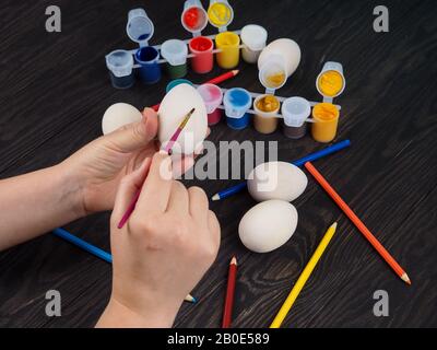 easter, family, holiday and concept - close up coloring eggs for easter. Stock Photo