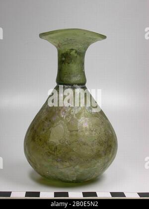 Roman bottle of greenish-blown glass. On the surface a vague decor of concentric circles in relief., To make the contents of a vase drop in drops from the opening, in the ancient times drippers were made, 'sprays'. The neck of these vases is closed on the inside by a slice of glass, which has a small opening in the middle. When the bottle is turned over, the perfume (or fragrant oil) comes out in drops., Crockery, glass, H 12 cm, Syria Stock Photo