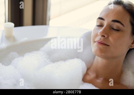 Young woman relaxing in bathtub Stock Photo