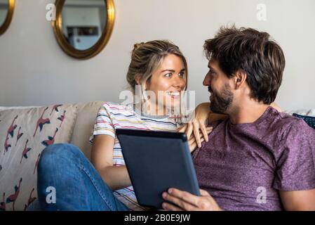 Couple using digital tablet at home Stock Photo