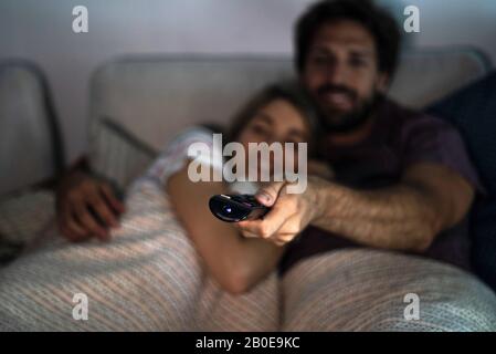 Close-up of man's hand operating remote control Stock Photo