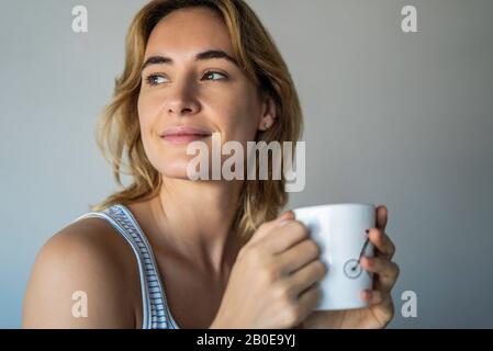 Young woman holding coffee mug Stock Photo